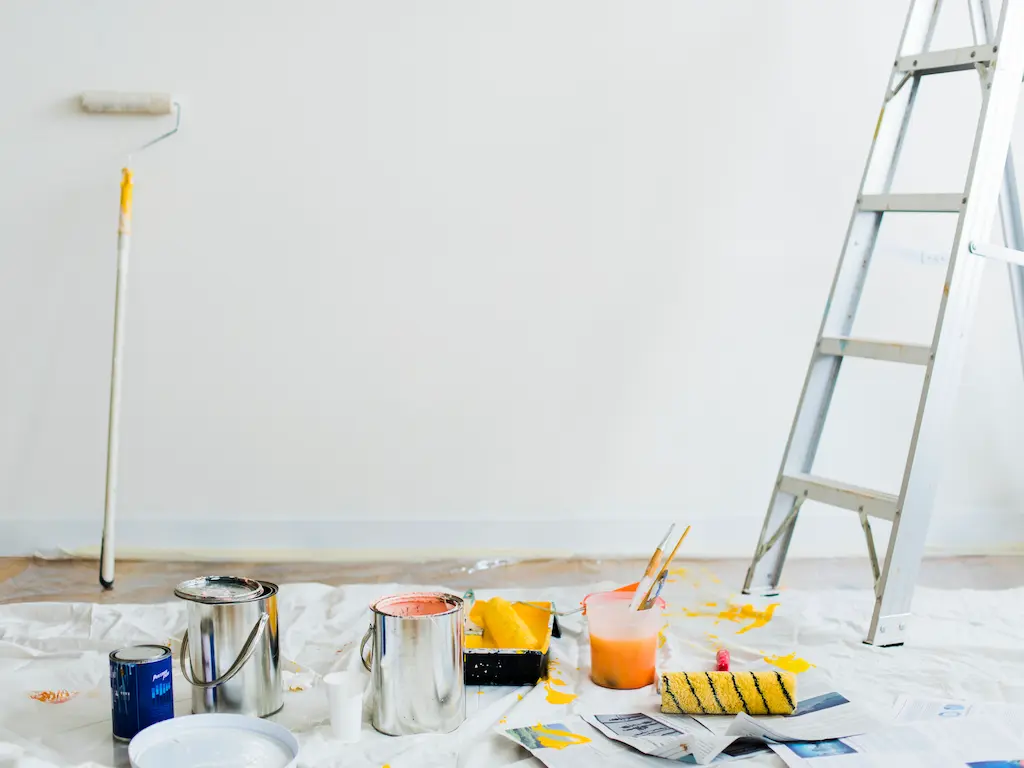 Festőeszközök, festékes vödrök és létra egy felújítás alatt álló helyiségben, ahol a Heat Builder Kft. a gépészeti munkák mellett az esztétikai helyreállítást is koordinálja.
